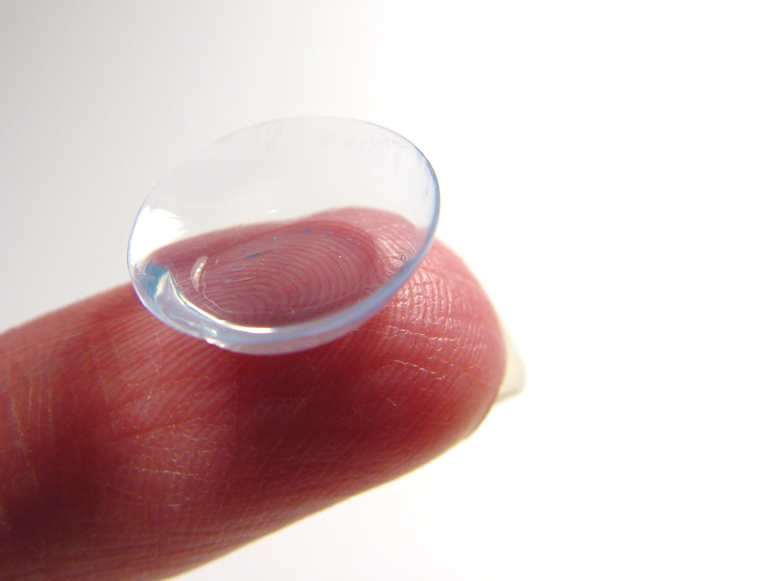 close up finger holding contact lens